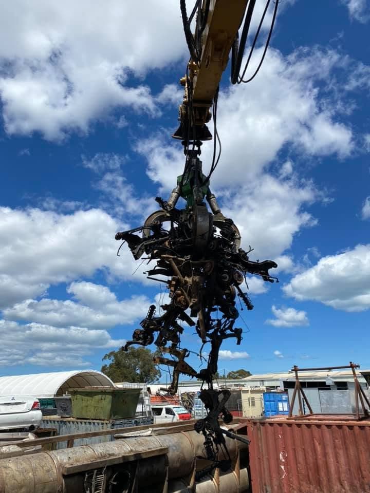 Hydraulic grab lifting a load of mechanical and suspension scrap